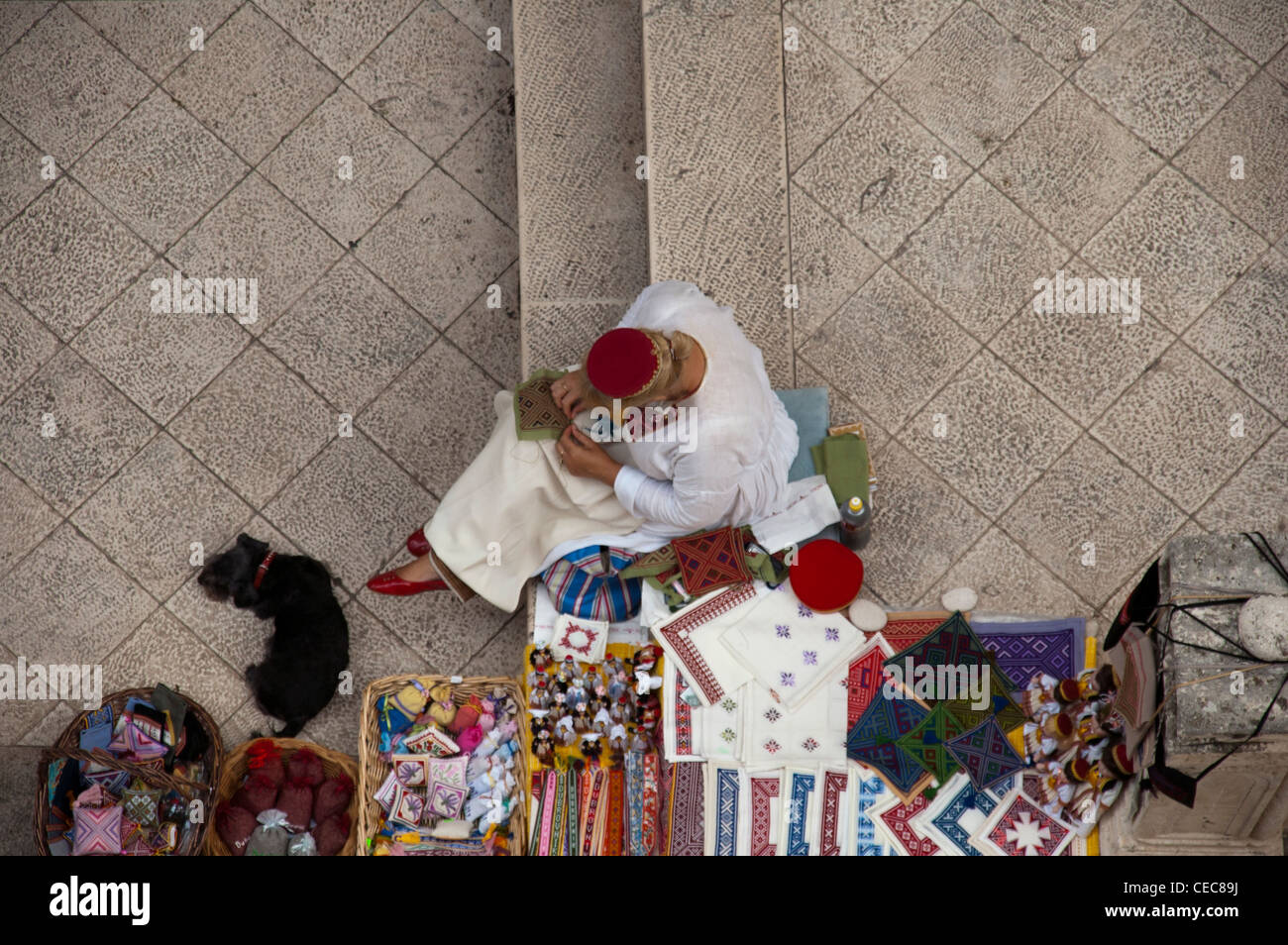 Frau verkauft traditionelles Handwerk und handgewebte Stoffe innerhalb der Mauern von Dubrovnik, Kroatien Stockfoto