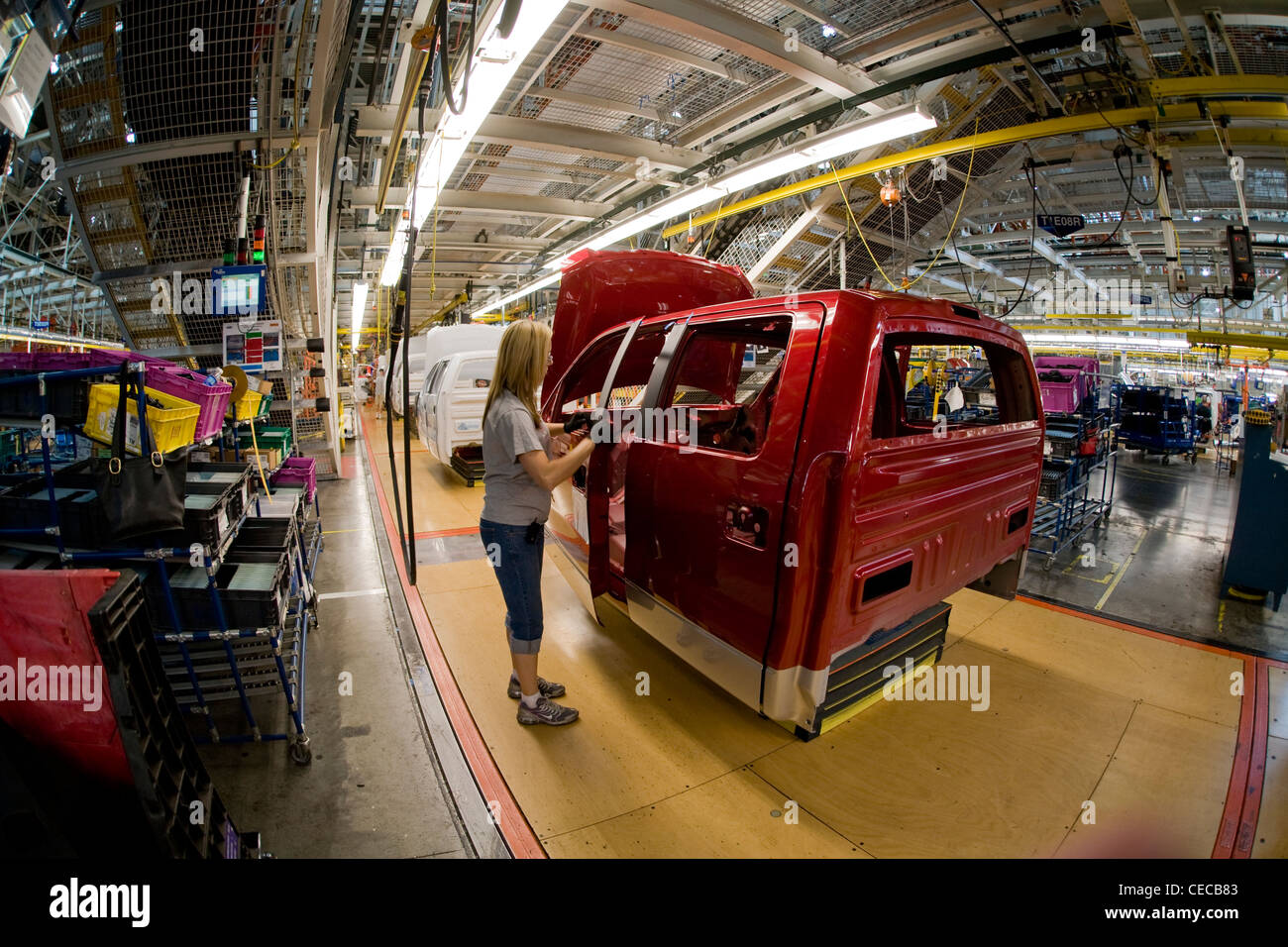 Ein Fabrikarbeiter Frau prüft neu installierte Türbeschläge auf einen f-150 Pickup-Truck im Ford-Werk zur Endmontage Stockfoto