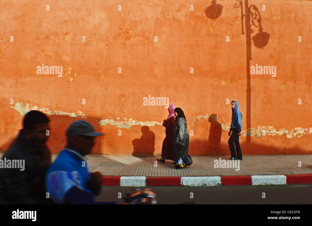Schatten und Fußgänger in einer Straße in Marrakesch, Marokko Stockfoto
