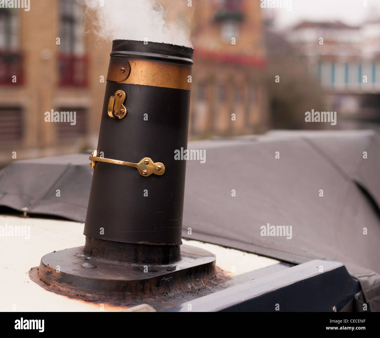 Schmale Boot am Kanal mit Rauchen Schornstein Ofen Stockfoto