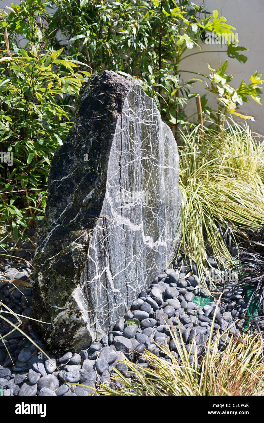 Probe grauen Stein als ein Brennpunkt-Feature in einem kleinen Garten Stockfoto