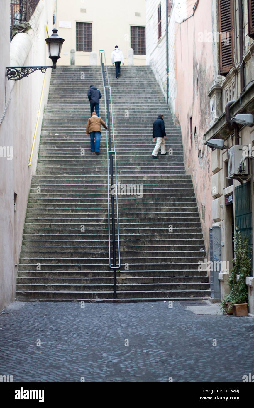 Vier Männer Klettern eine sehr steile Stein Treppe in Roma Italien Stockfoto