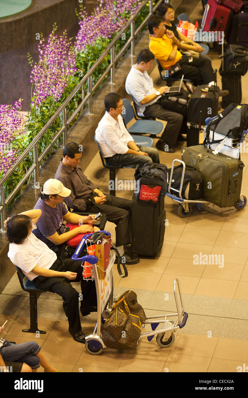 Passagiere warten zum Check-in am Flughafen Changi in Singapur Stockfoto