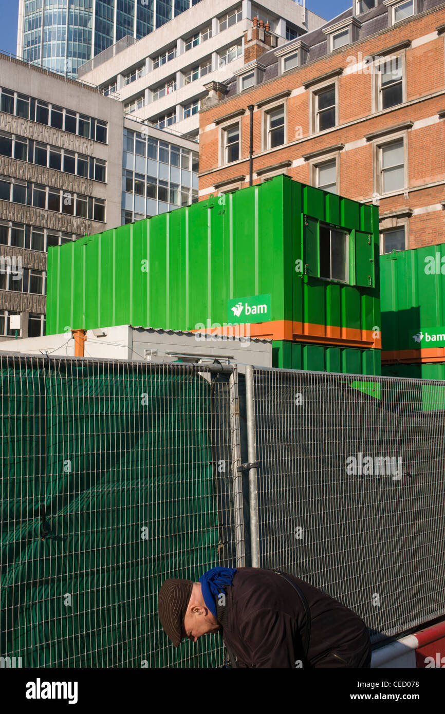 Älterer Mann und Hintergrund des städtischen Gebäuden und temporären Bauens Baubüro Container in der City of London. Stockfoto