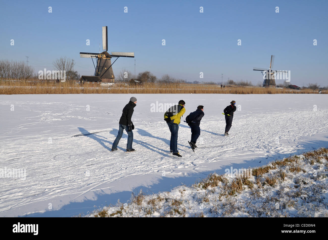 Eisläufer und Windmühlen von Kinderdijk, Niederlande, Europe Stockfoto