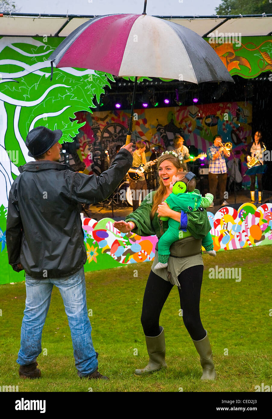 Mutter und Kind tanzen im Regen unter Väter Dach am Aeon festival Stockfoto