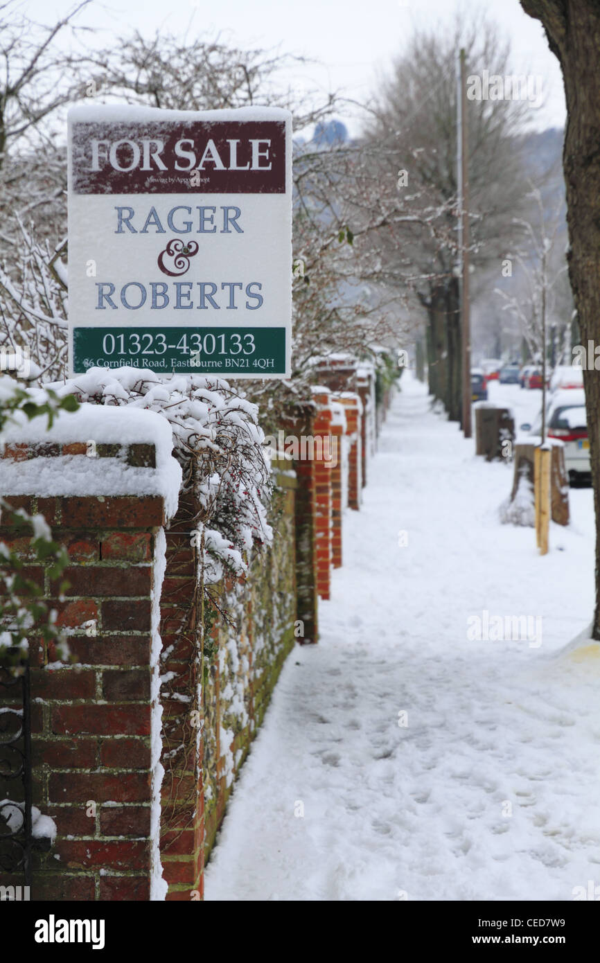 Neue Haus-Eigenschaft für Verkauf Werbung Board anmelden Straße in den kalten Wintermonaten winterlichen Schnee verschneiten Tag Wetter uk Stockfoto