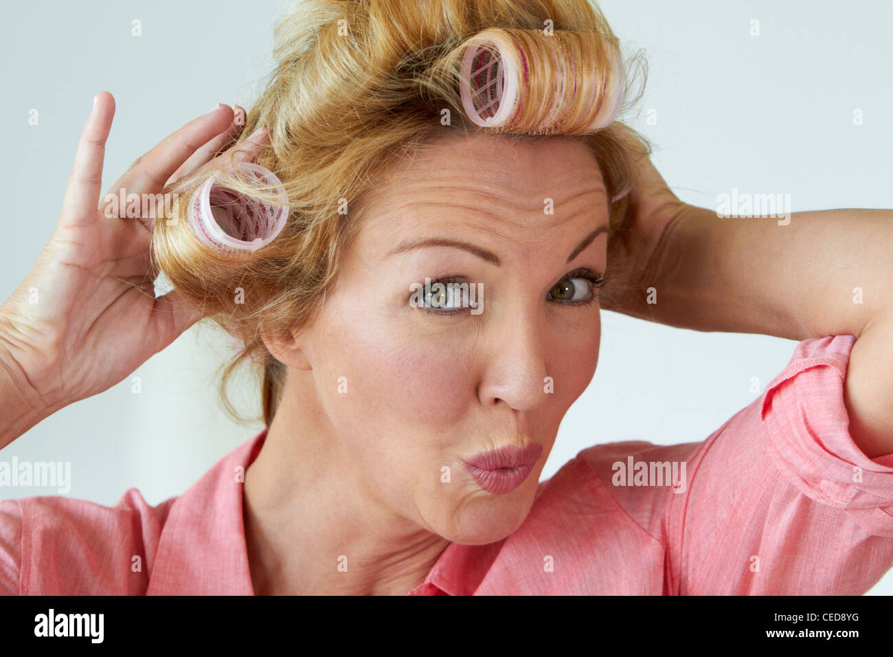 Kaukasische Frau setzen Rollen im Haar Stockfoto