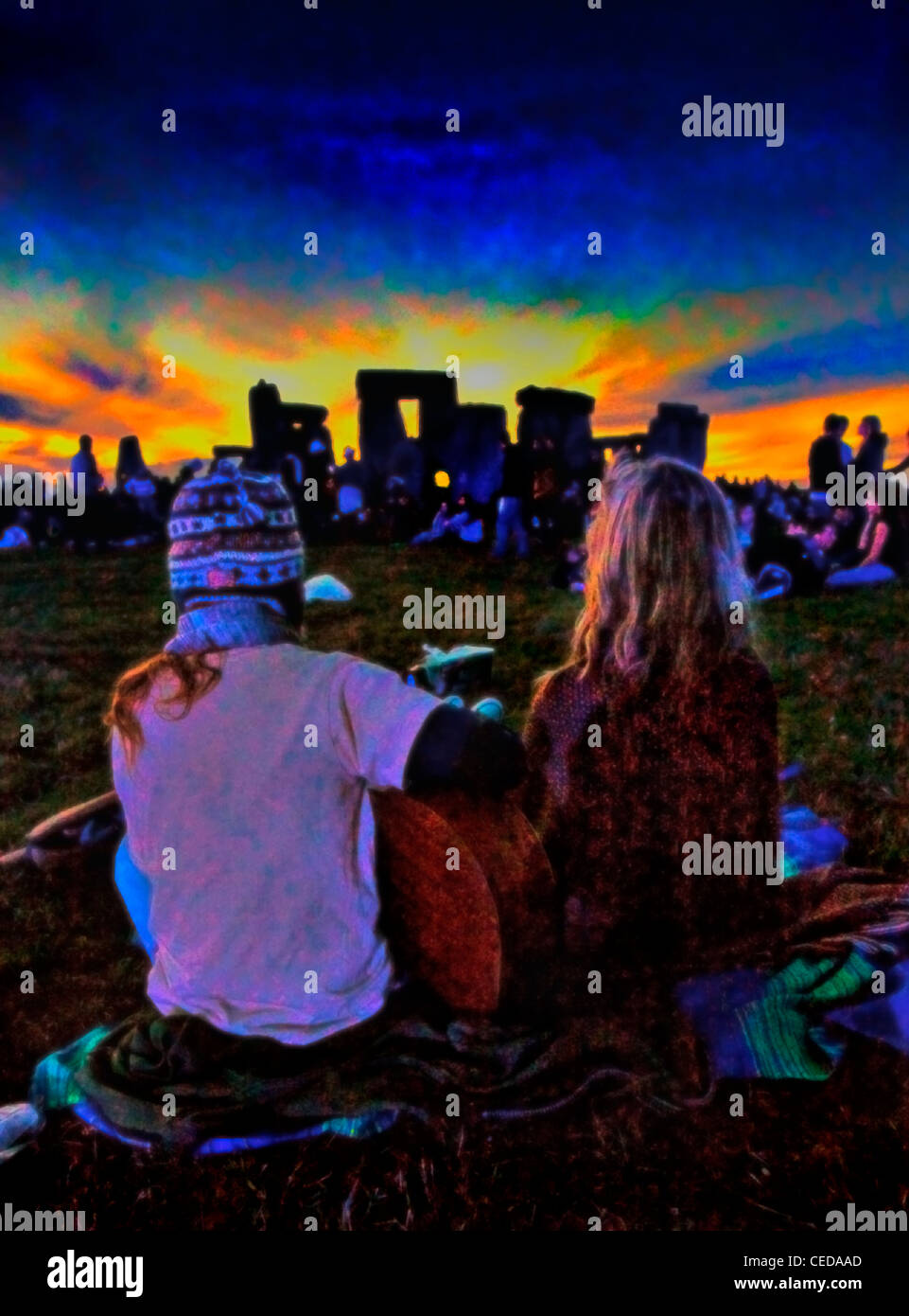 Ein junger Hippie Paaruhr den Sonnenuntergang während Gitarrenspiel auf Stonehenge Sommersonnenwende Festival Stockfoto