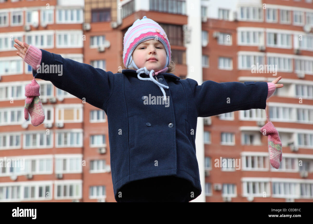 kleines Mädchen mit geschiedenen Händen gegen Hintergrund Gebäude Stockfoto