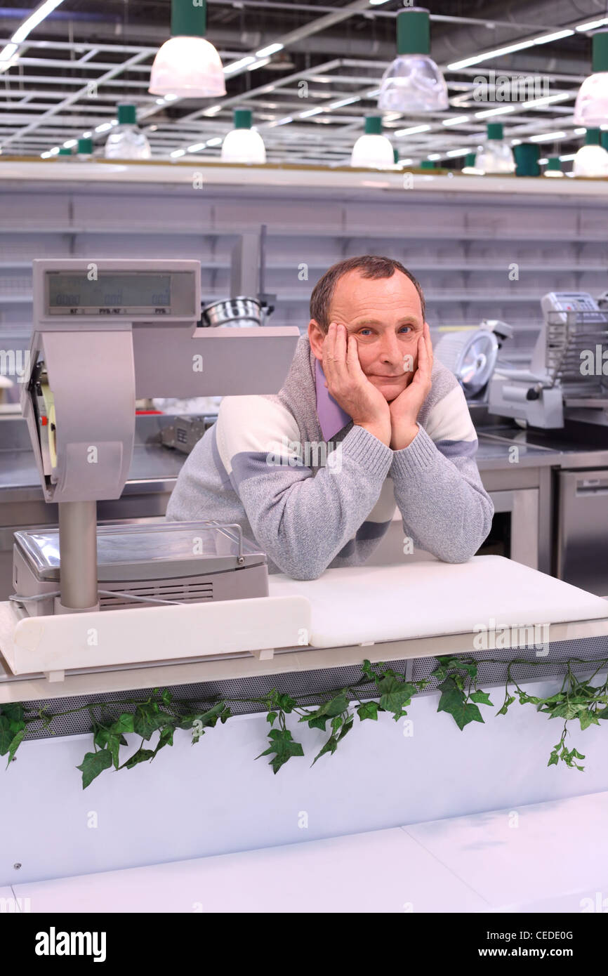 gelangweilte Verkäufer im Shop mit leeren Regalen und Theken Stockfoto