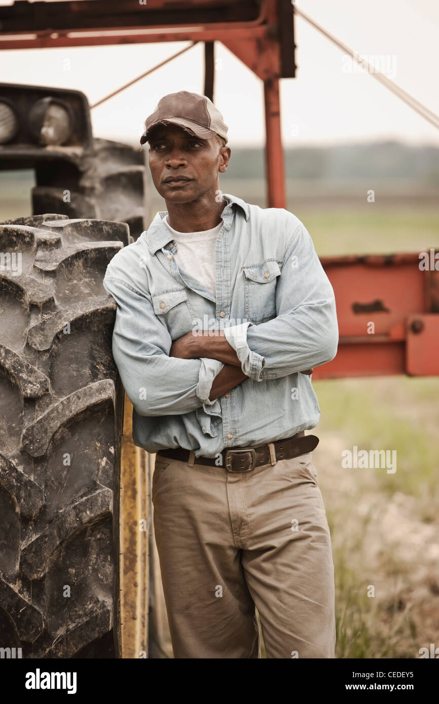 African American Farmer stehen in der Nähe von Traktor Stockfoto