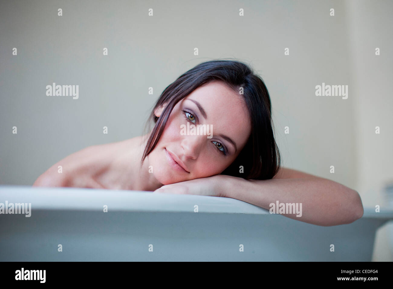 Kaukasische Frau stützte sich auf Seite der Badewanne Stockfoto