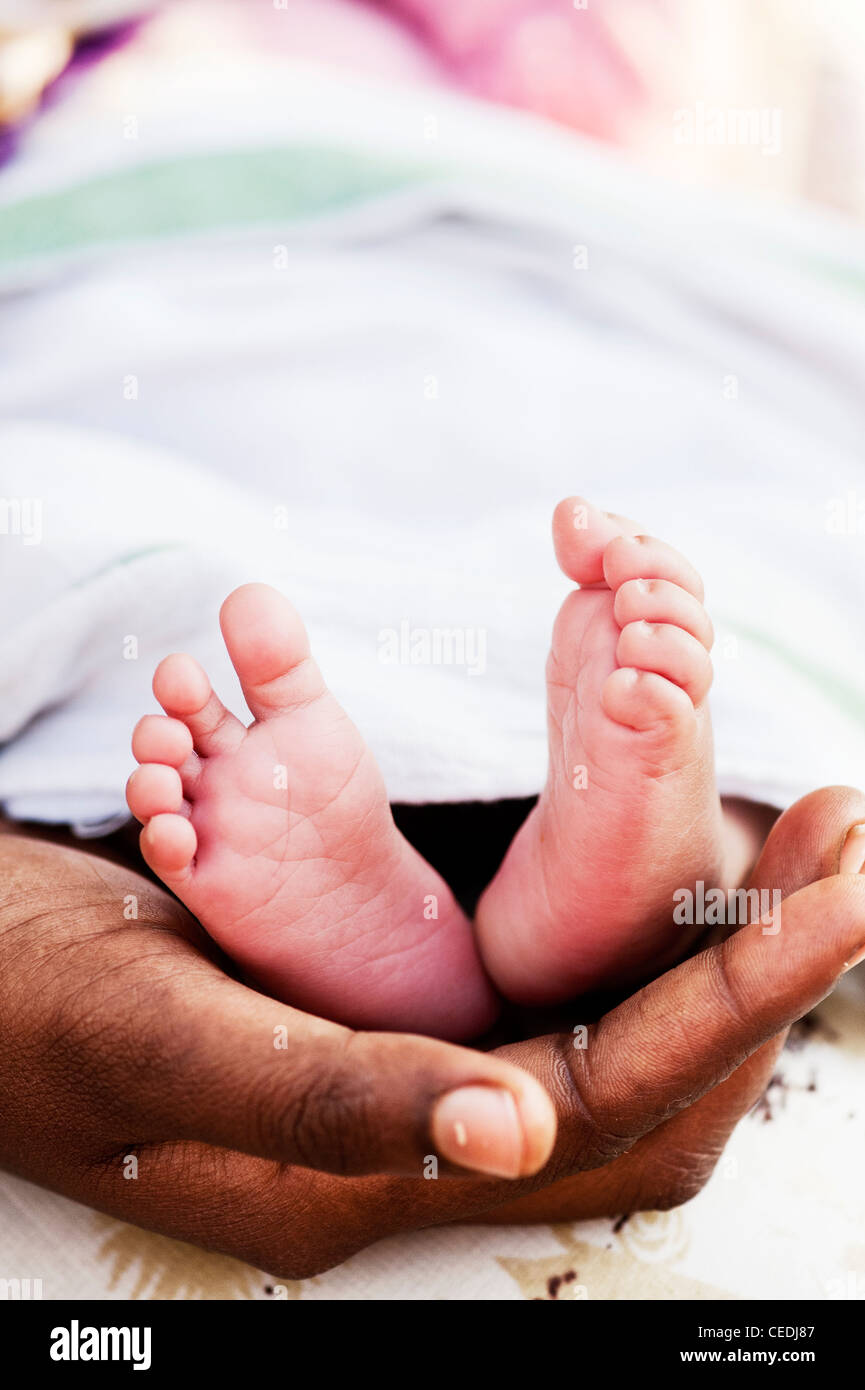Indische Mutter hielt ihren Neugeborenen nackten Füßen. Andhra Pradesh, Indien Stockfoto