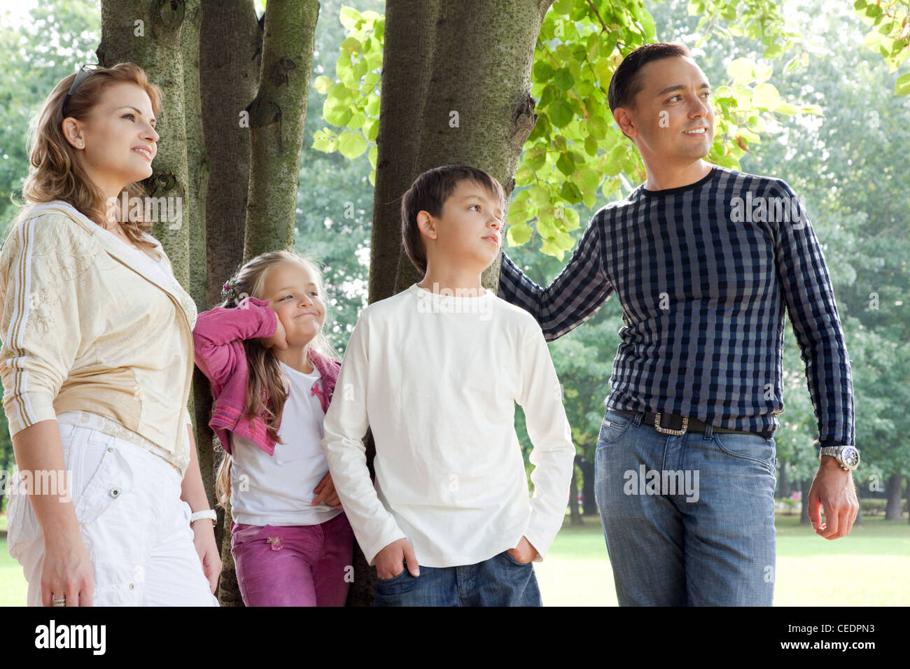 lächelnde glückliche Familie von vier suchen beiseite im freien Stockfoto