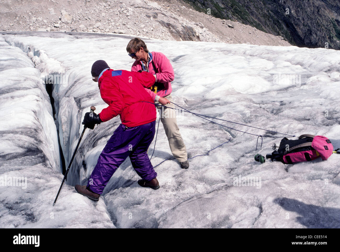 Ein Leitfaden hilft ein Wanderer Peer in eine Gletscherspalte auf dem Malloy Gletscher im Bereich von Bugaboo der alten Purcell Mountains in British Columbia, Kanada. Stockfoto