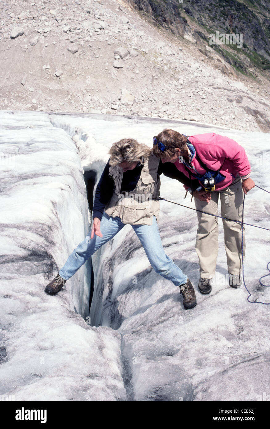 Ein Leitfaden hilft ein Wanderer Peer in eine Gletscherspalte auf dem Malloy Gletscher im Bereich von Bugaboo der alten Purcell Mountains in British Columbia, Kanada. Stockfoto
