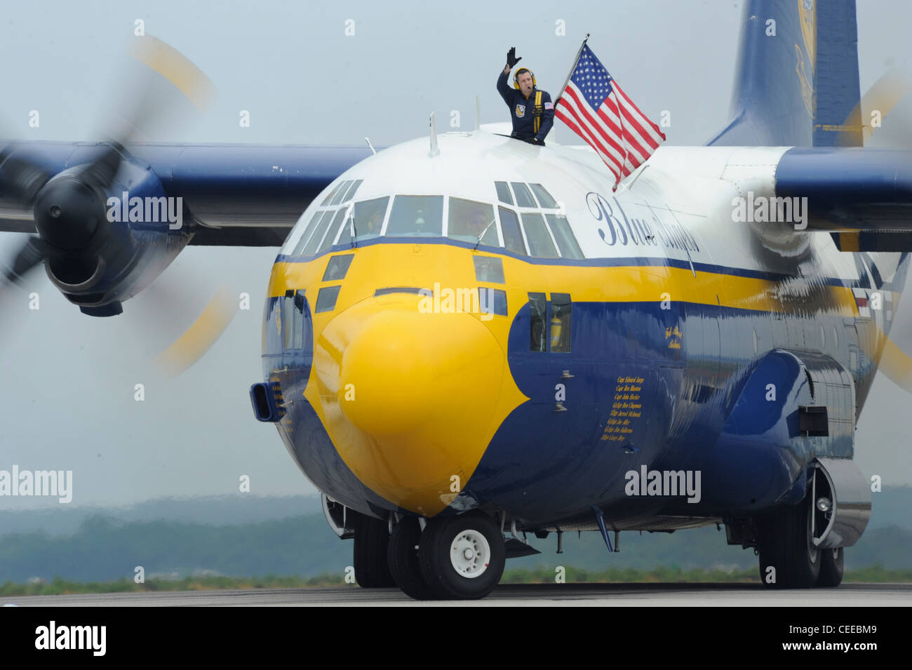 Marine Gunnery Sgt. Joe Alley, ein C-130 Navigator, der dem U.S. Navy Flight Demonstration Squadron, den Blue Angels, zugewiesen wurde, winkt der Menge zu, nachdem Fat Albert, der Blue AngelsÕ C-130 Hercules, während der Rhode Island National Guard Open House Air Show landet. Die Blue Angels traten in Rhode Island während der Show-Saison 2011 und zur Feier des 100. Jahrestages der Marineflieger auf. Stockfoto