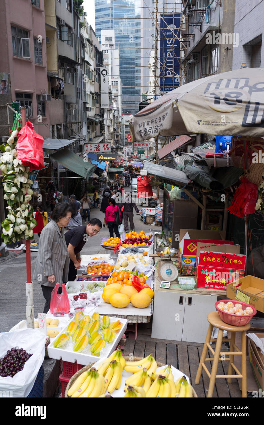 dh Midlevels CENTRAL HONG KONG Streetscene chinesische Frau Obststand Halter Steet Markt Display Straßenverkäufer außerhalb der asien-Szene Stockfoto