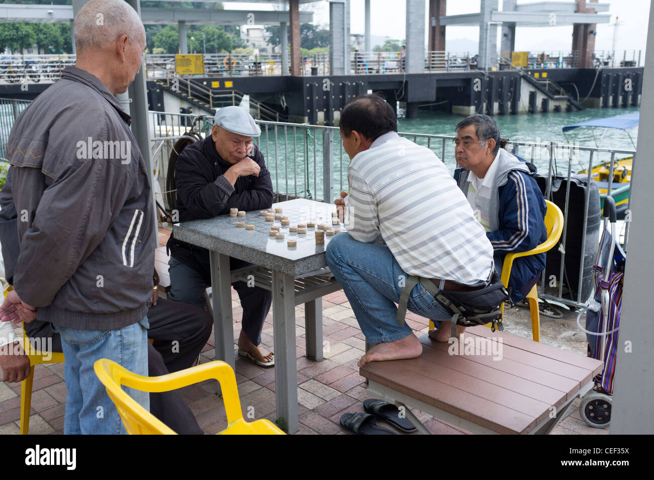 dh Brettspiel Xiangqi PENG CHAU INSEL HONGKONG CHINA Männer spielen chinesisches Schach Einheimische Dame asien Menschen Erwachsene Spiele Stockfoto