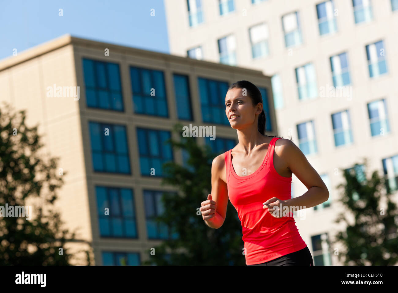 Urbane Sportarten - junge Frau Joggen für Fitness in der Stadt an einem schönen Sommertag Stockfoto