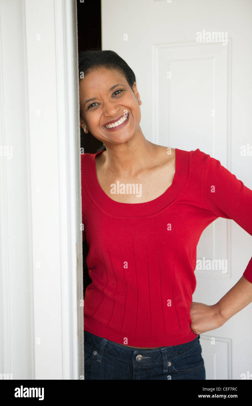 Glücklich schwarze Frau Gruß Besucher an der Haustür Stockfoto