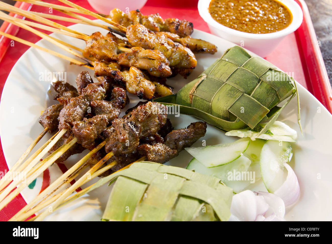 Huhn und Lamm Satay Spieße mit Ketupat Reis und Erdnuss-Sauce Stockfoto