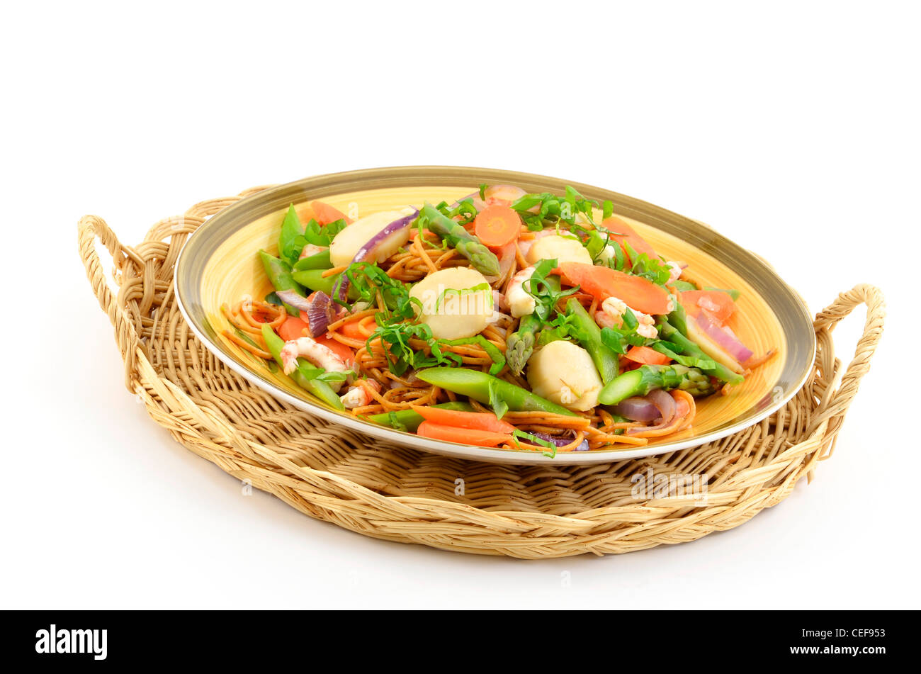 Jakobsmuscheln, Garnelen und Spargel brach Nudeln auf Korbwaren Tablett isoliert auf weiss mit Textfreiraum Stockfoto