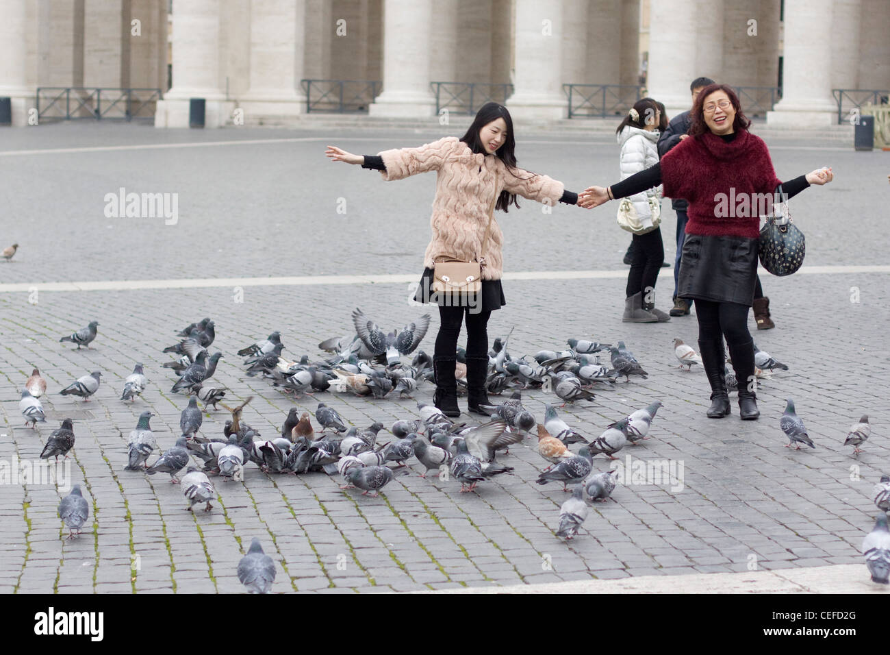 Zwei chinesische Damen posieren mit den Tauben in der St. Peter Basilika Basilica di San Pietro Vatikanstadt Rom Stockfoto