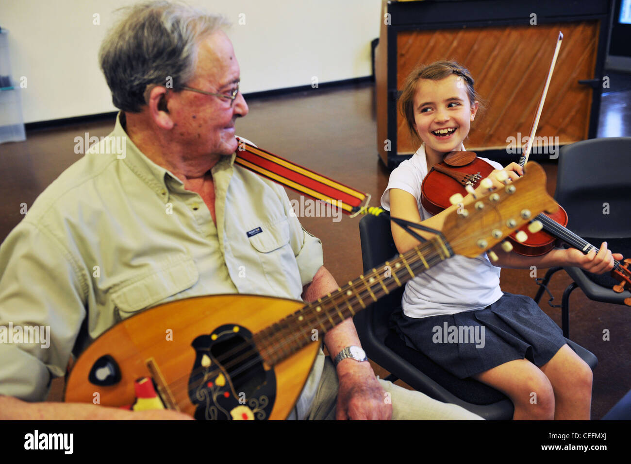 Zwischen den Generationen Orchester, jung und alt musizieren gemeinsam in einer Grundschule UK Stockfoto