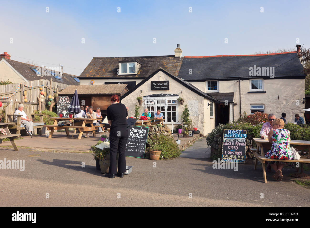 Die Hexe Ball 15. Jahrhundert freehouse Pub mit Menschen an Tischen, die Mahlzeiten im Freien genießen, Sonne sitzen. Lizard Cornwall England Großbritannien Großbritannien Stockfoto