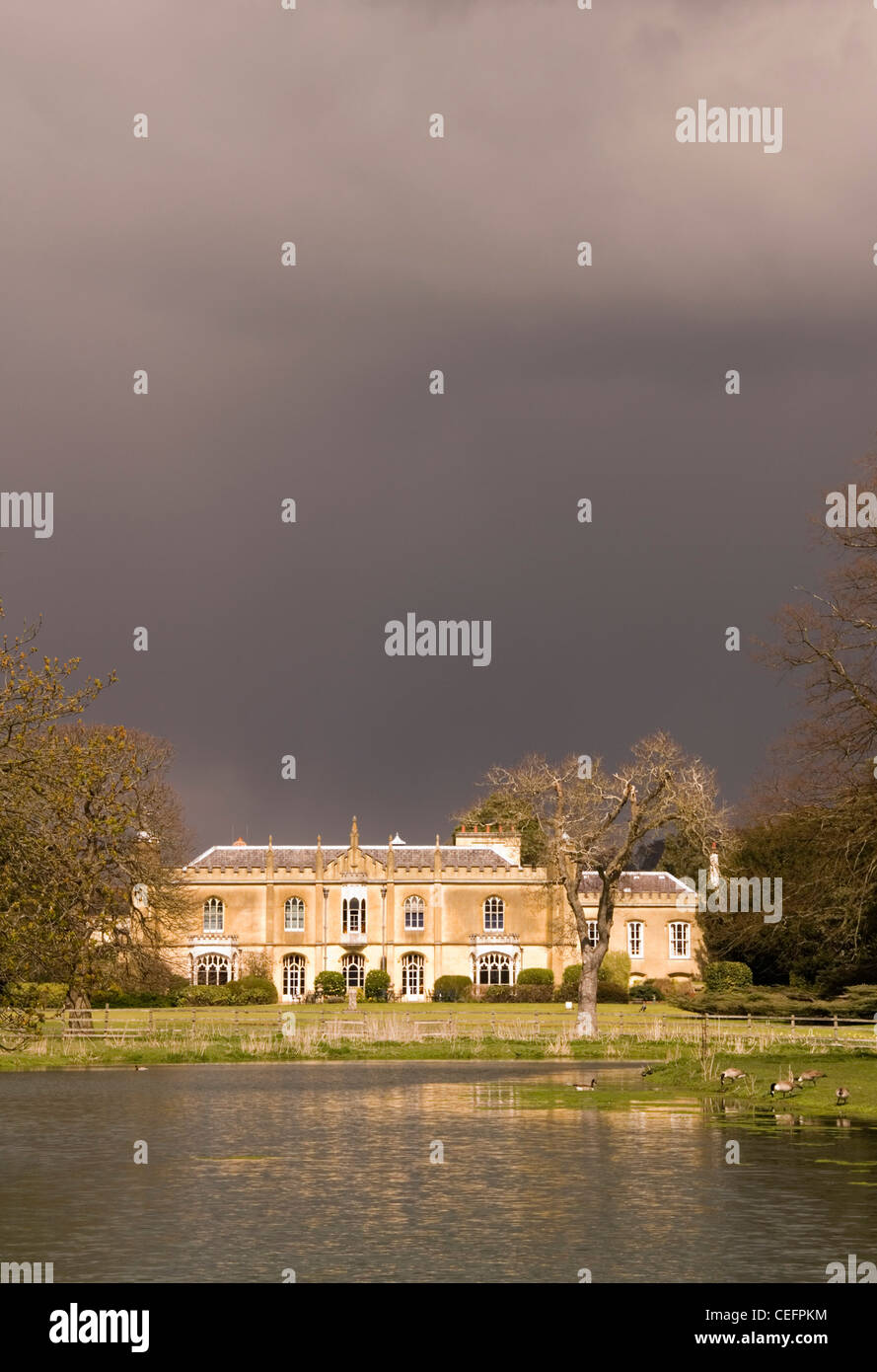 Great Missenden - Missenden Abbey - Sonne beleuchtet unter Gewitterwolken - spiegelt sich in einem See Stockfoto