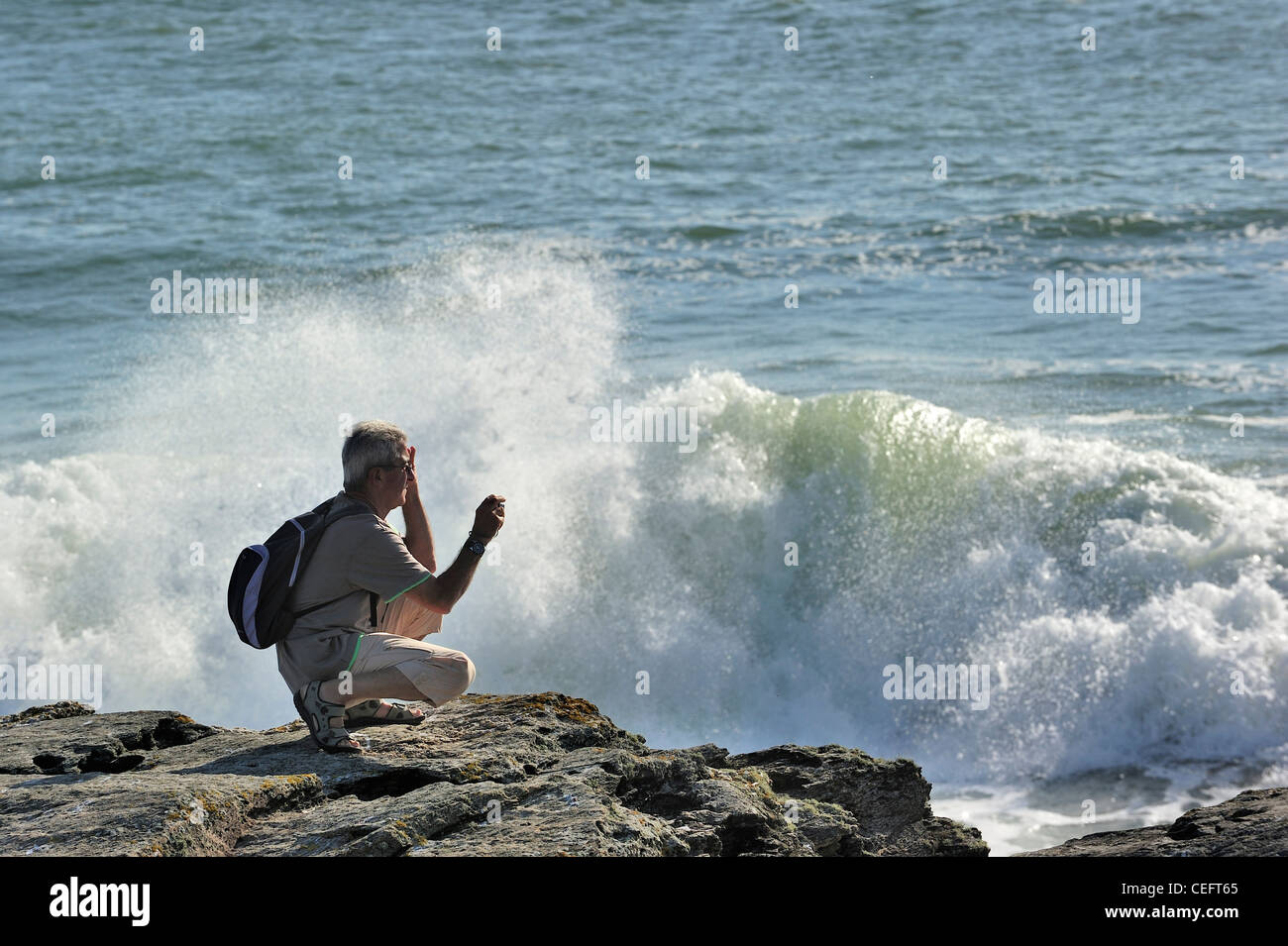 Touristen fotografieren der Wellen auf den Felsen am Pointe Saint-Gildas /  Saint Gildas Point, Loire-Atlantique, Frankreich Stockfotografie - Alamy