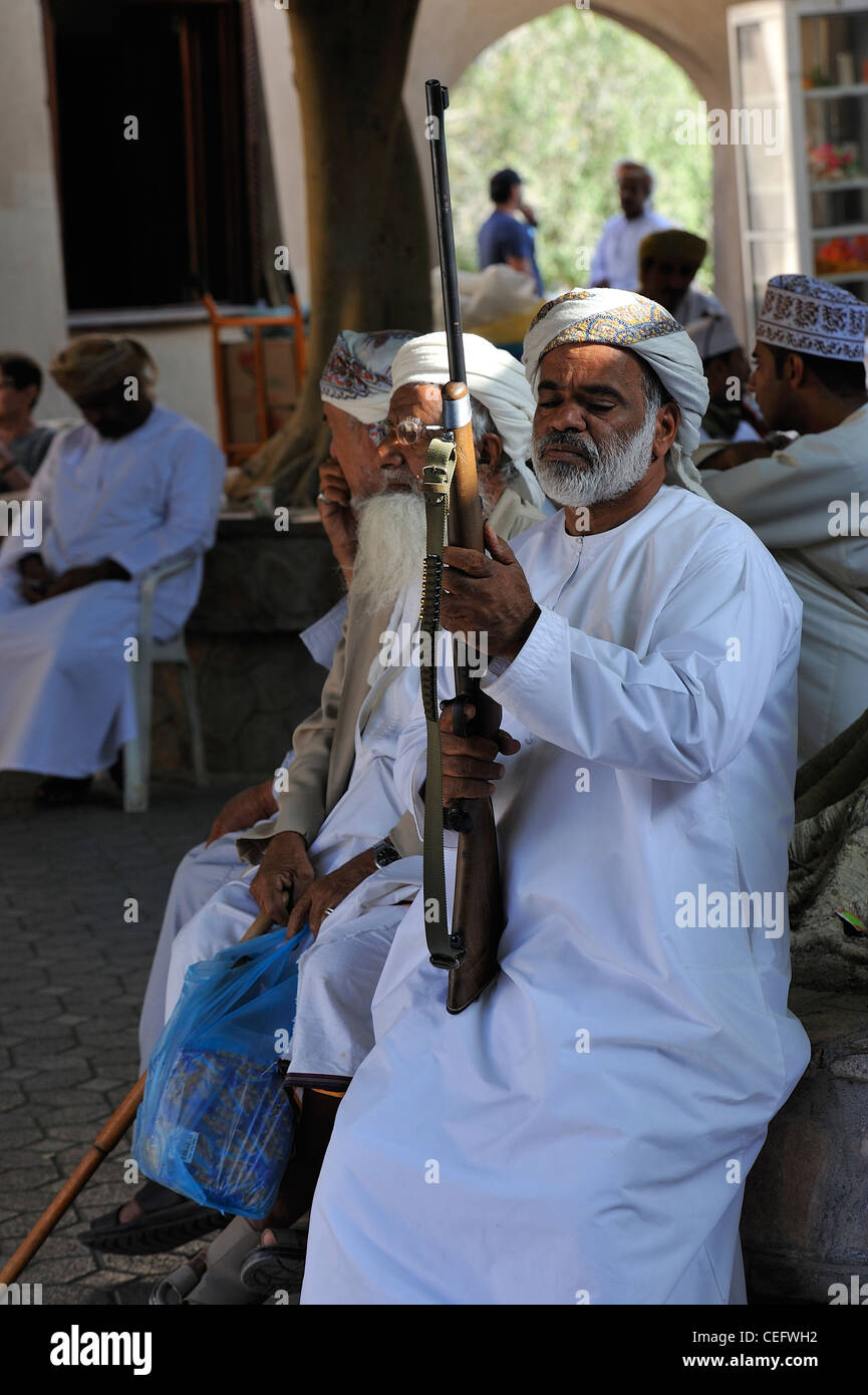 Omanische Mann überprüfen Sie sein Gewehr vor dem Kauf in den alten Souk Nizwa; Al Dakhiliyah, Oman. Stockfoto