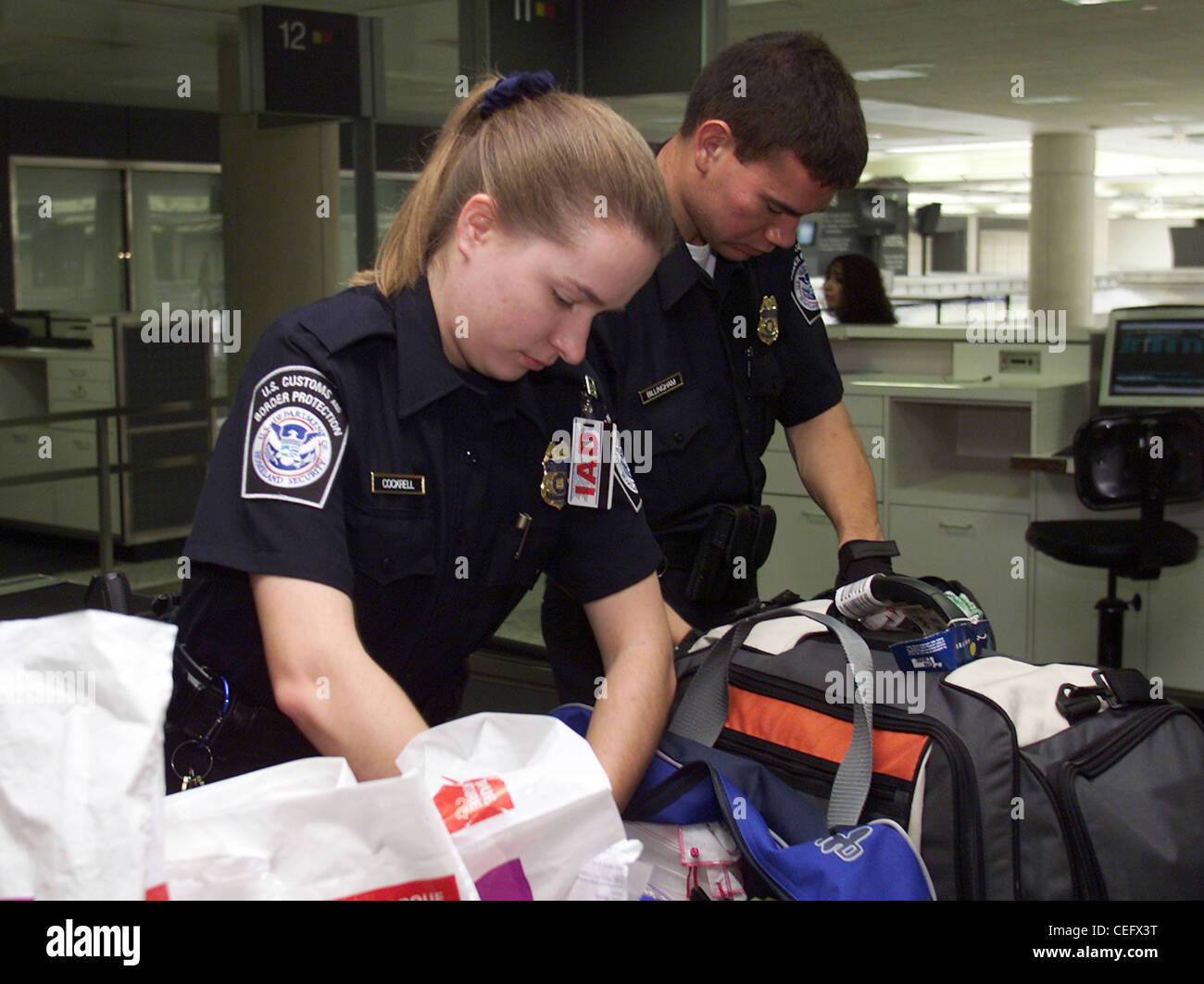 CBP Offiziere Überprüfen eines Individuums Gepäck. Stockfoto