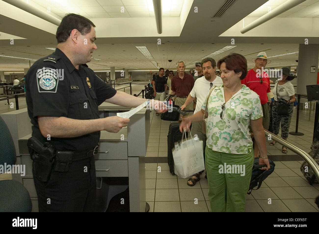 Ein CBP-Officer prüft ein Passagier Dokumentation nach der Ankunft in den USA Stockfoto