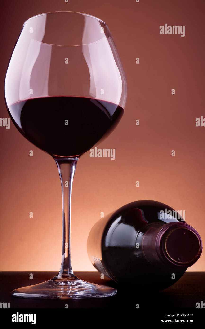Glas und eine Flasche Rotwein, einem braunen Vignettierung Hintergrund. Stockfoto