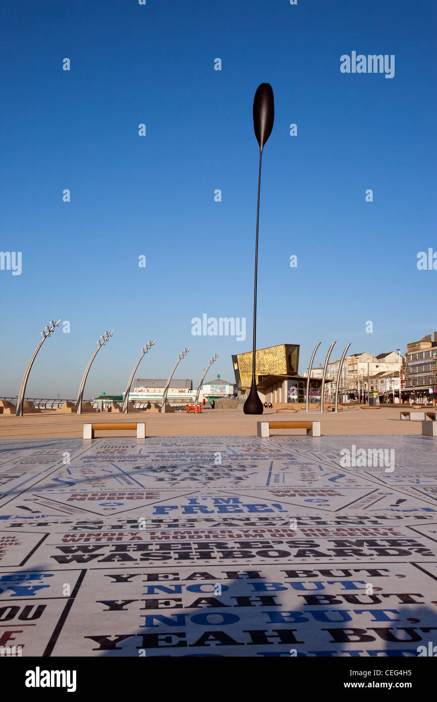 Komödie-Teppich und andere Kunstwerke auf zentralen promenade in Blackpool mit goldene Hochzeitskapelle im Hintergrund. Stockfoto