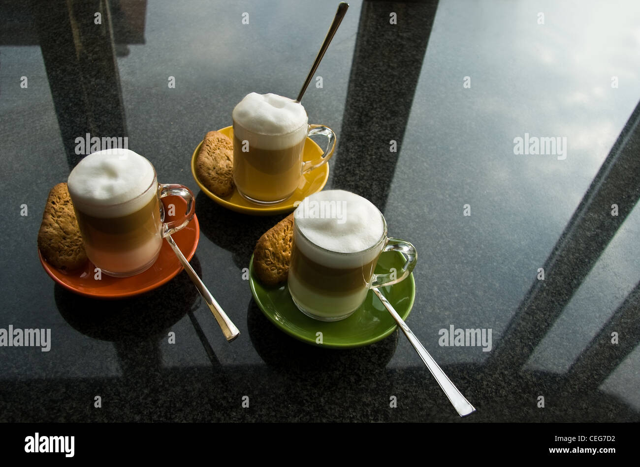 Schwarzer Granit Küche Kommode mit drei Glas Tassen "Café au Lait", bunten Untertassen und Reflexion von Fenster Stockfoto