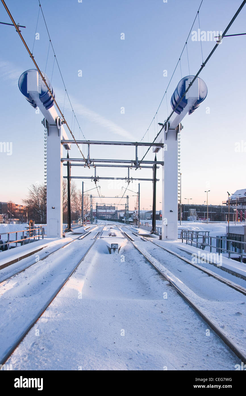 Trainieren Sie heben Brücke im Schnee am frühen Wintermorgen - vertikales Bild Stockfoto