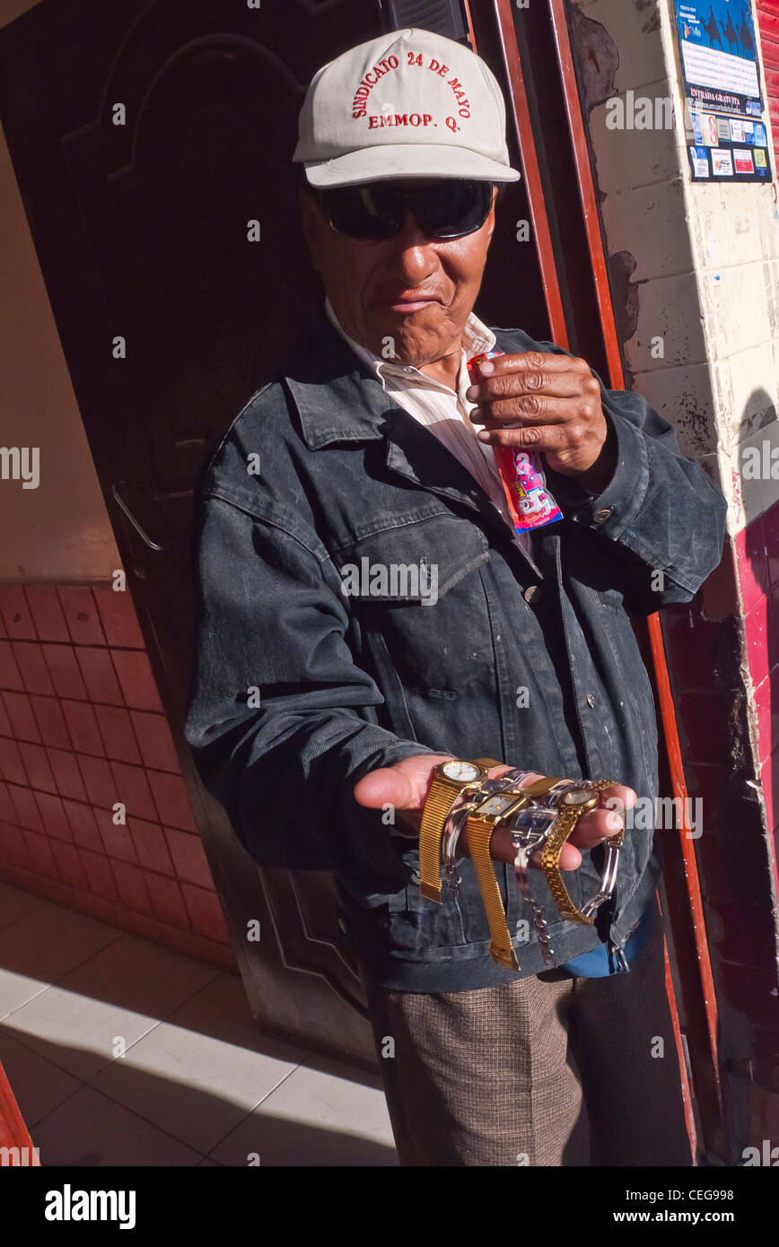 Ein Hispanic Mann in den Fünfzigern hält seine Hand mit Armbanduhren zum Verkauf in Latacunga, Ecuador. Stockfoto