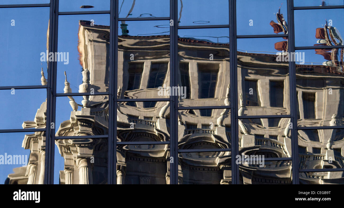 Reflexionen eines Gebäudes im neoklassizistischen Stil spiegelt sich in den Fenstern ein modernes Glas-Hochhaus verzerrt. Stockfoto