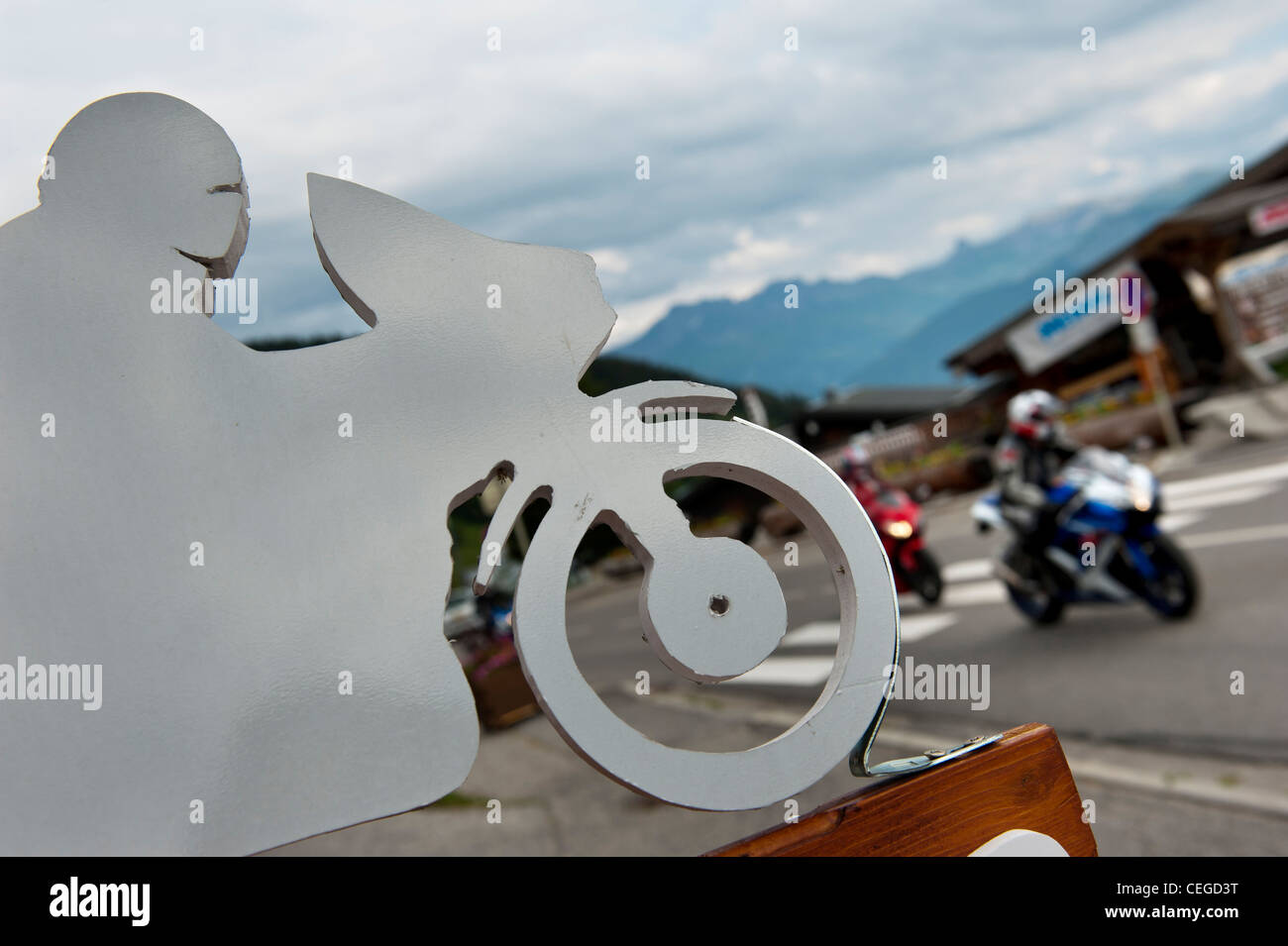 Motorradfahrer passieren eine motor-Radfahrer-Schild in Les Saisies Village Resort. Savoie. Frankreich Stockfoto