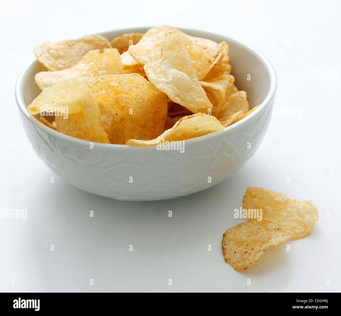 Chips in eine Schüssel geben Stockfoto