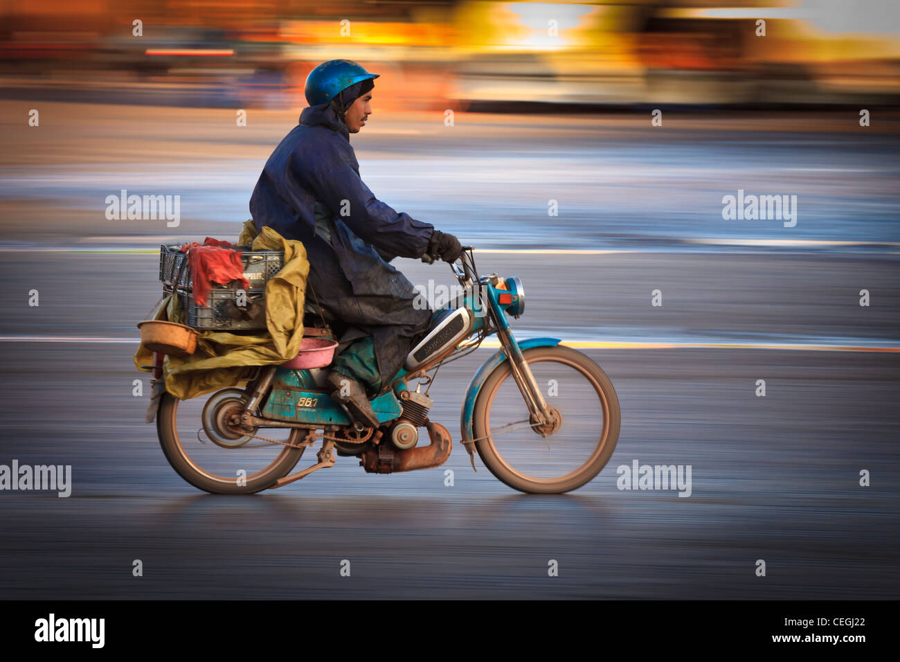 Ein Mann fährt ein Moped im Morgenlicht, Marrakesch, Marokko Stockfoto