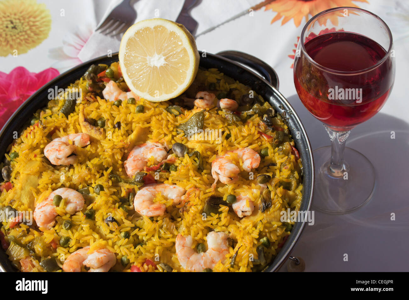 Spanische Meeresfrüchte Paella und ein Glas Rotwein. Stockfoto