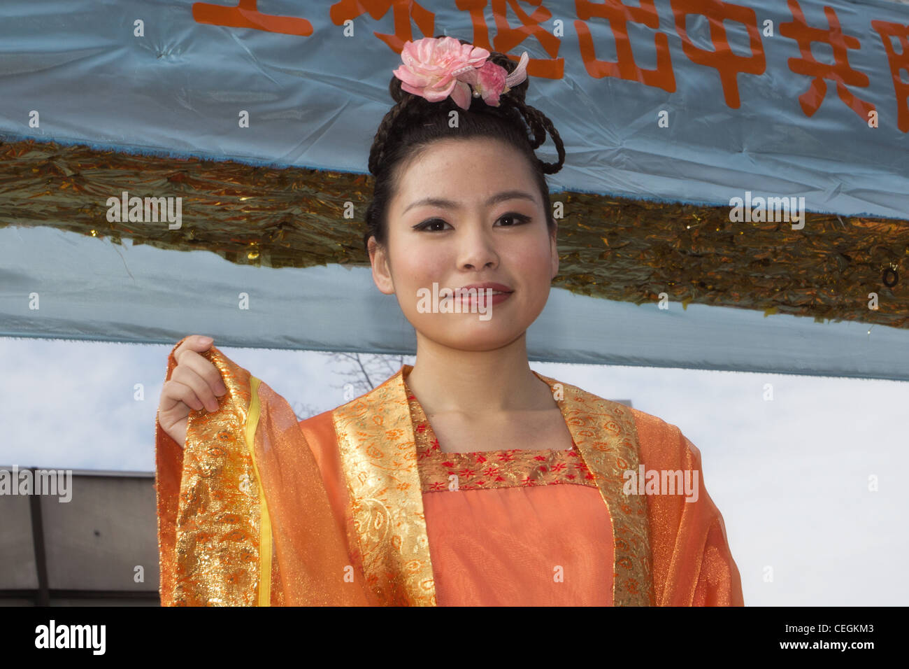 Chinesisch-amerikanische Frau gekleidet in traditioneller Tracht Wellen aus der Falun Gong-Schwimmer in der 2012-Chinese Lunar New Year-parade Stockfoto