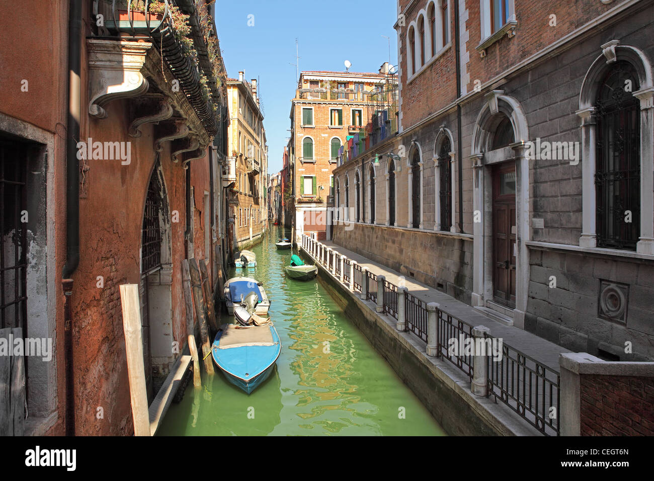 Horizontales Bild des kleinen engen Kanal mit Booten unter alten historischen Häuser in Venedig, Italien. Stockfoto