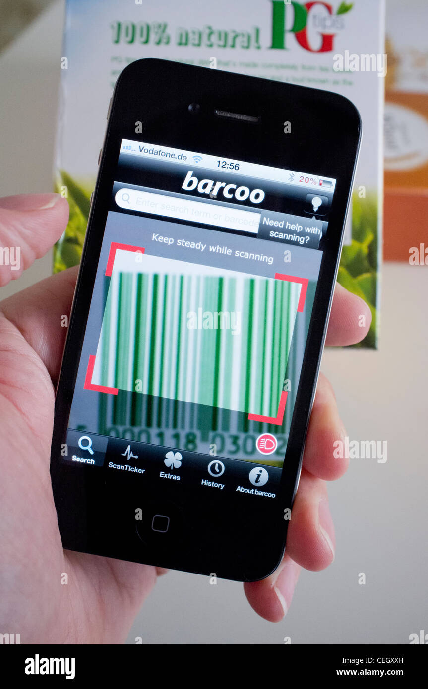 Scannen von Barcodes auf Packung Tee im Shop auf ein iPhone 4 G Smartphone Preisvergleich finden Stockfoto