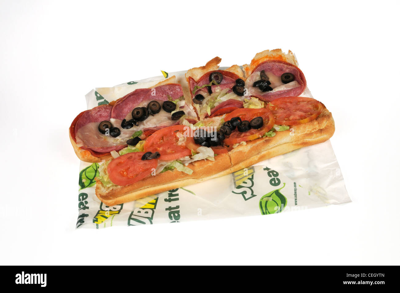 U-würzigen italienischen Wurstwaren footlong submarine Sandwich mit Salat, Tomaten schwarze Oliven auf Wrapper auf weißem Hintergrund Ausschnitt USA. Stockfoto